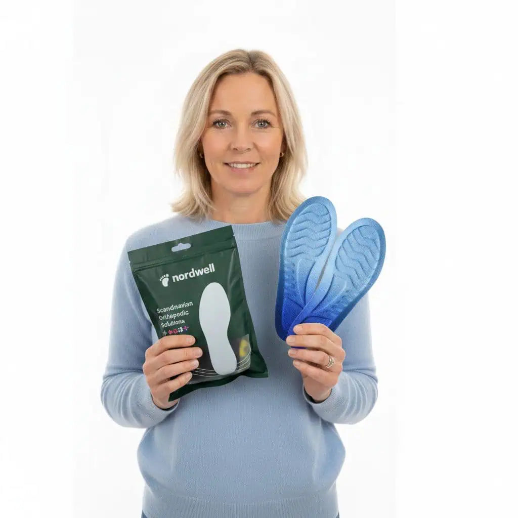 Kvinna som håller ortopediska skoinlägg från NordWell mot vit bakgrund
