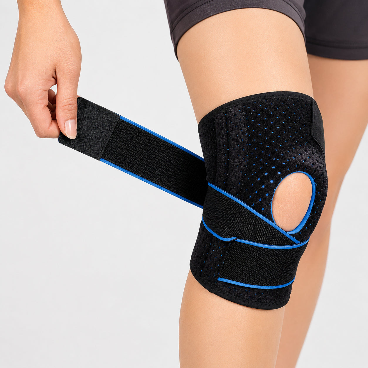 Knäskydd med dubbla sidostabilisatorer, patellaöppning och justerbar kompressionsrem för stabilitet och avlastning.