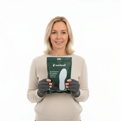 En kvinna som bär artrithandskar som lindrar stelhet och ledvärk i händerna från NordWell